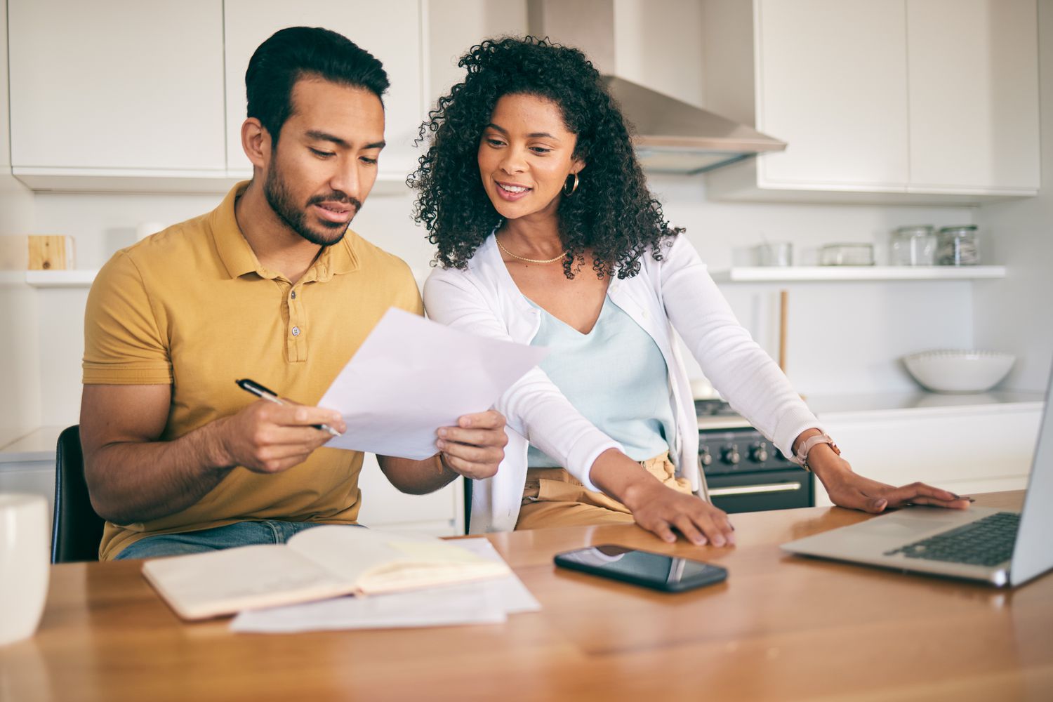 A first-time homebuyer calculating how much house they can afford using a budget worksheet.