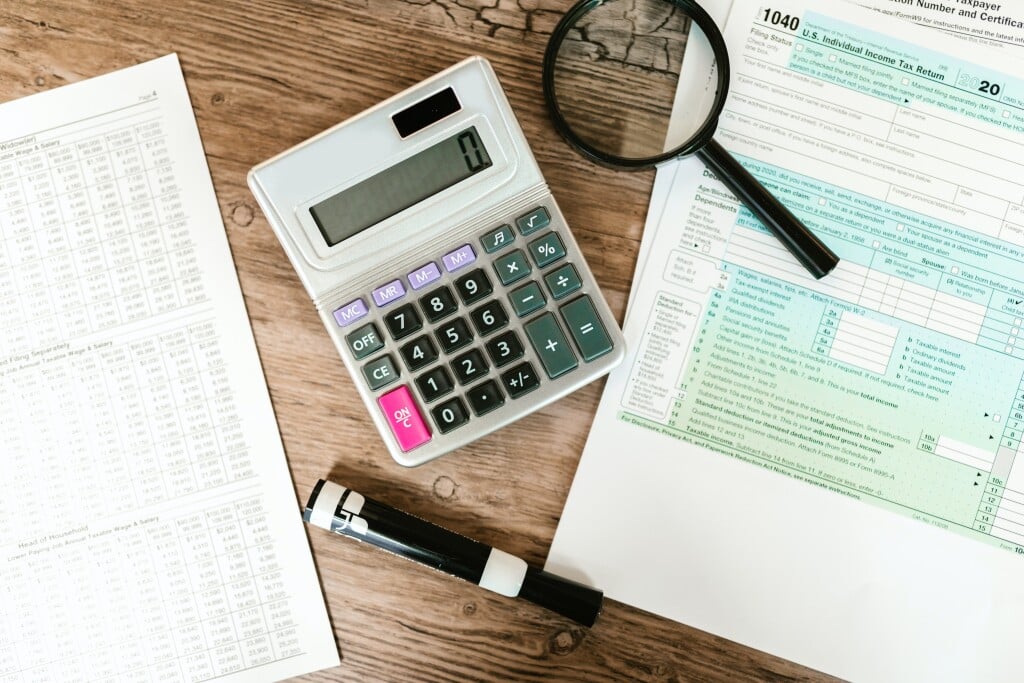 Calculator and tax documents on a wooden desk for bank statement mortgage
